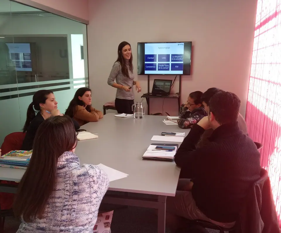 Capacitación en la sala de reuniones: una persona presenta frente a la pantalla